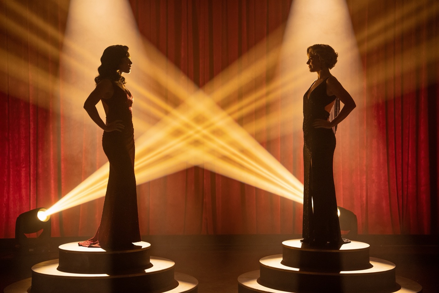 Two rival AI showgirls silhouetted on twin spotlit podiums, gold haze rising before the first round